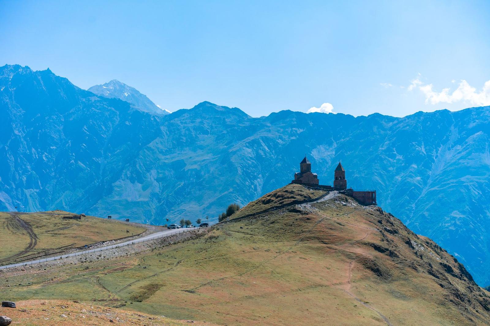 Stunning view of Gergeti Trinity Church atop a hill against majestic Georgian mountains