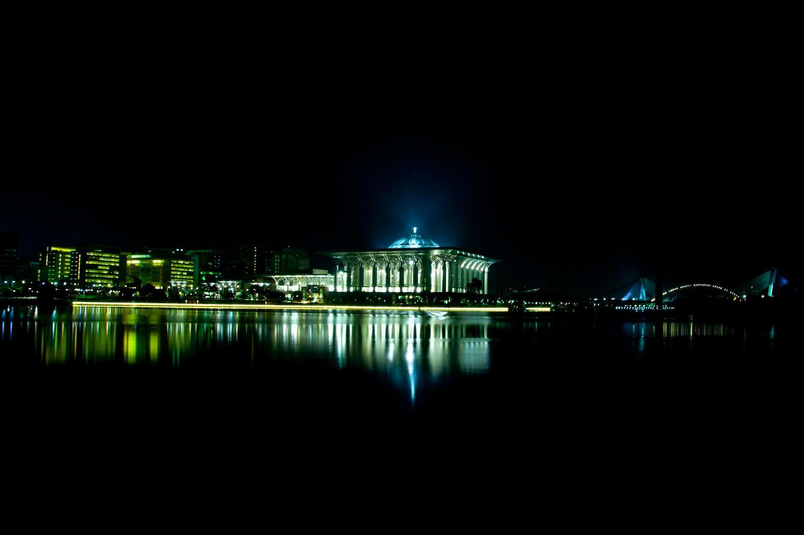 A breathtaking night view of the Iron Mosque reflecting on the water in Putrajaya, Malaysia