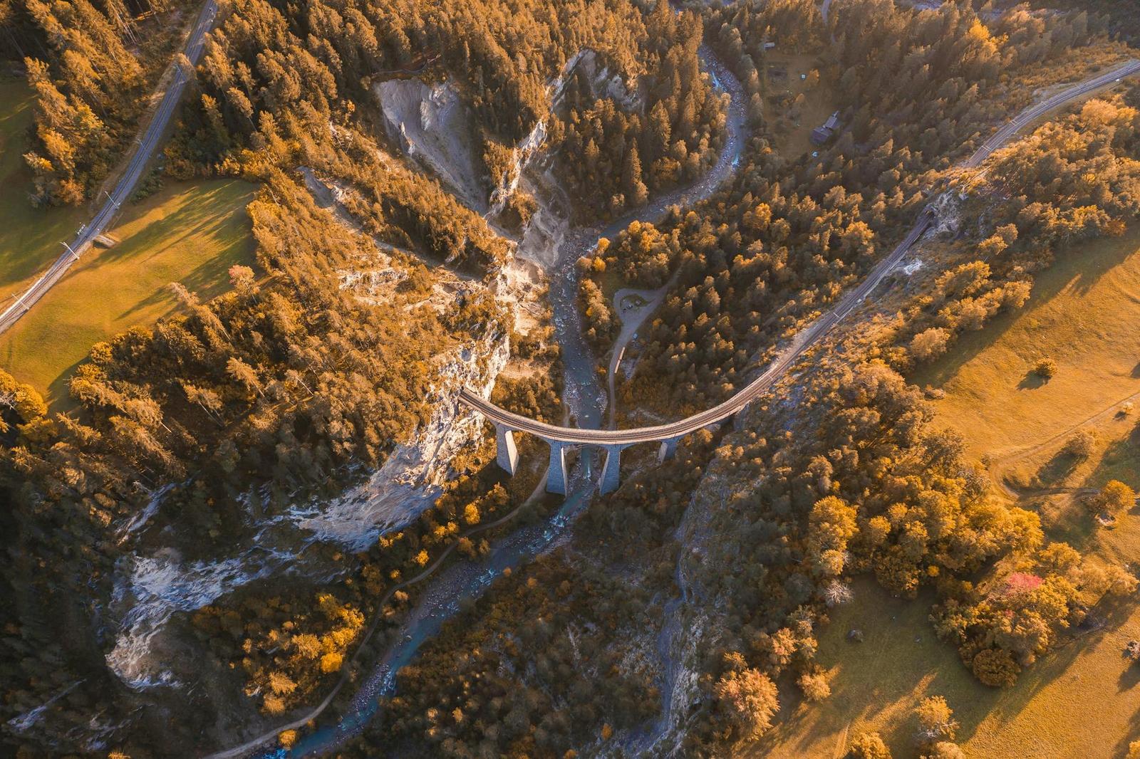 Aerial view of a viaduct crossing a forested gorge in autumn colour