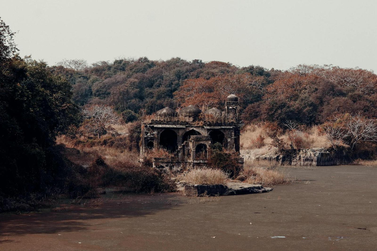 Weathered ruined pavilion standing beside a dry riverbed