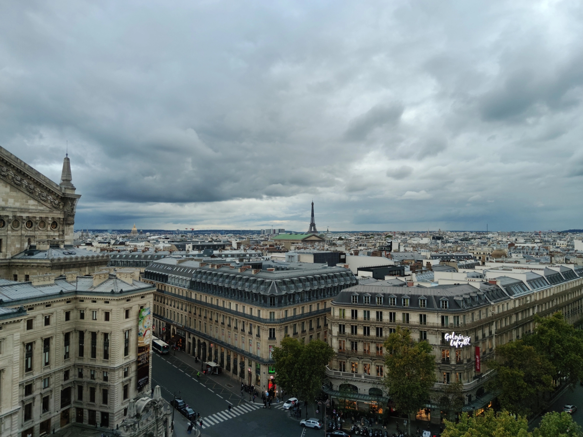 A stunning panoramic view of Paris showcasing the iconic Eiffel Tower under cloudy skies