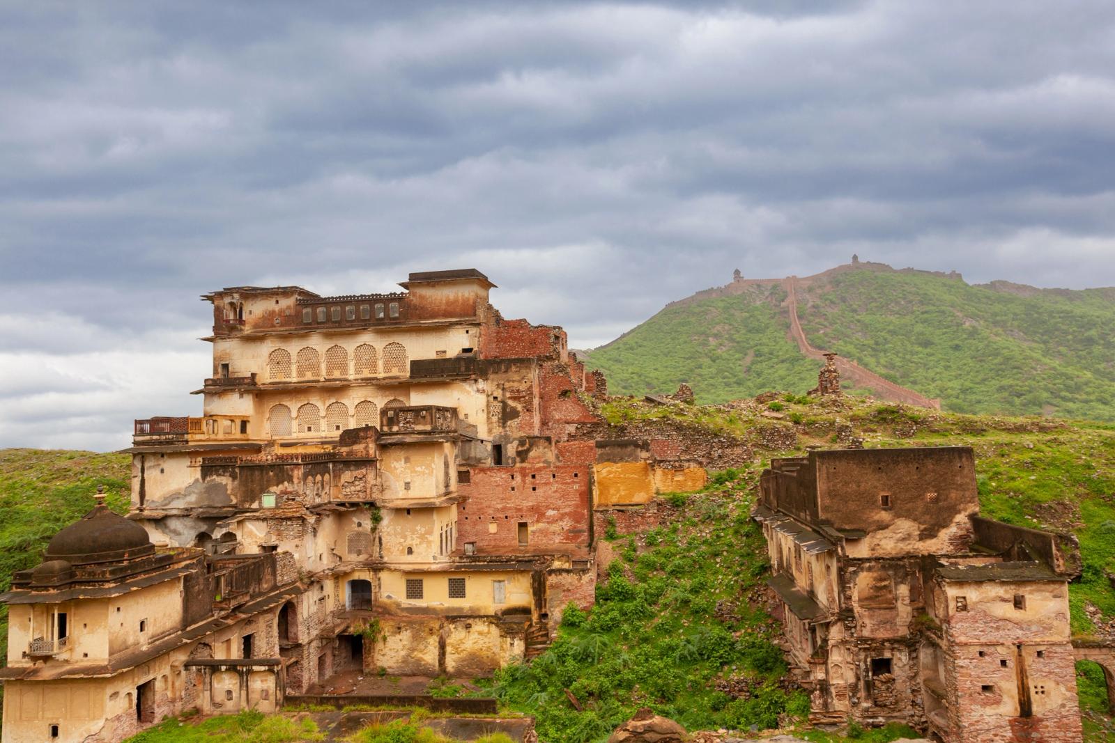 Old palace ruins in Rajasthan, India, with scenic hills and dramatic skies