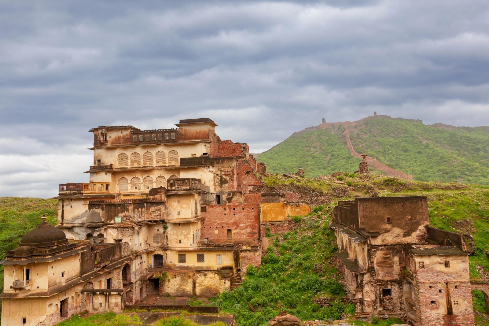 Old palace ruins in Rajasthan, India, with scenic hills and dramatic skies