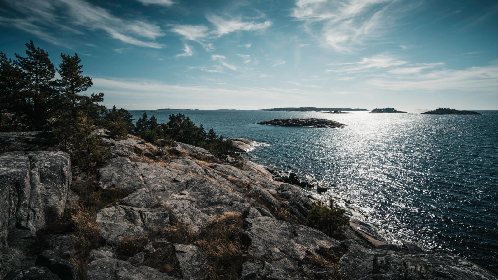 Breathtaking view of Finland's rocky coastline with sparkling sea and distant islands