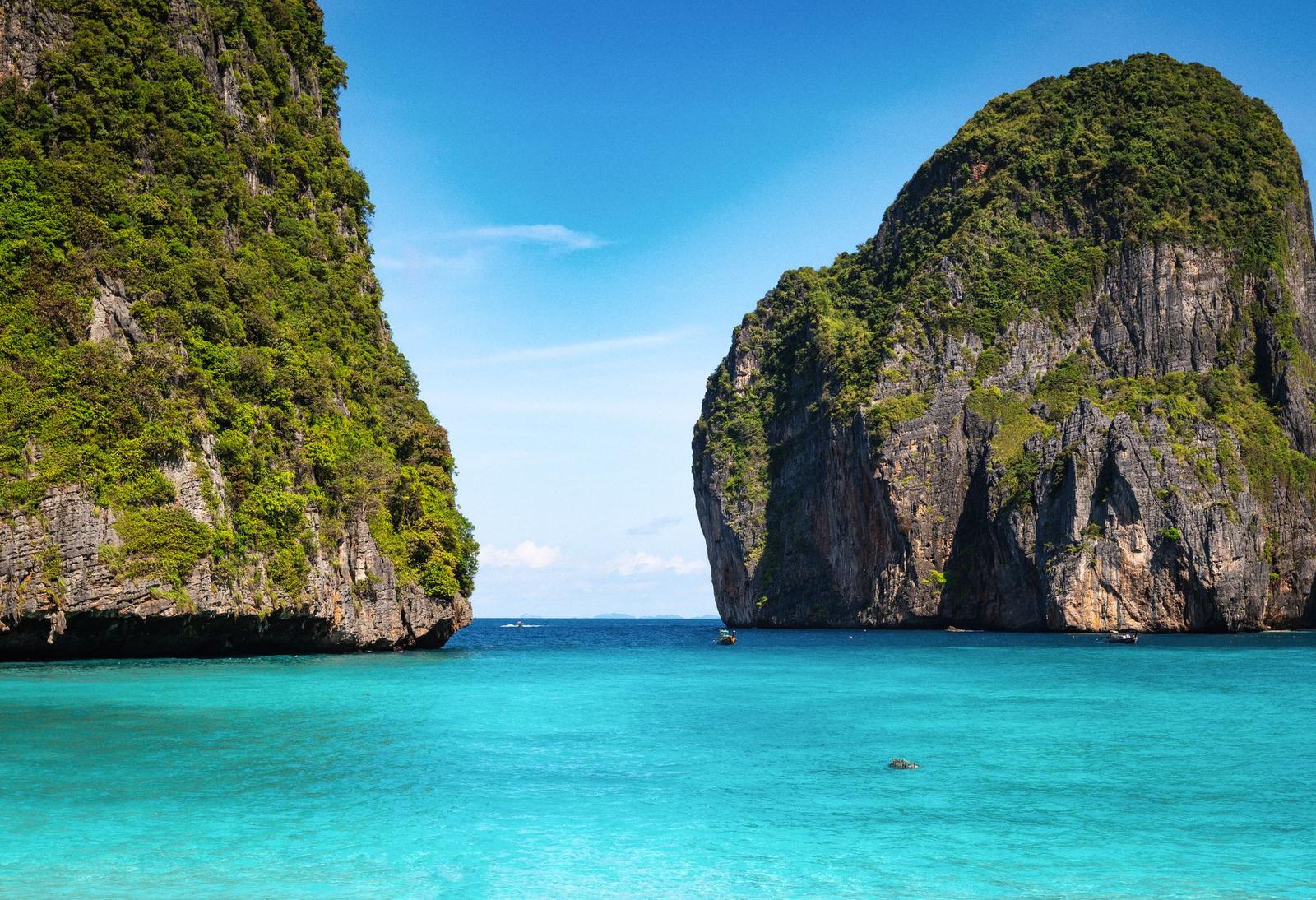 Turquoise lagoon squeezed between two towering limestone cliffs