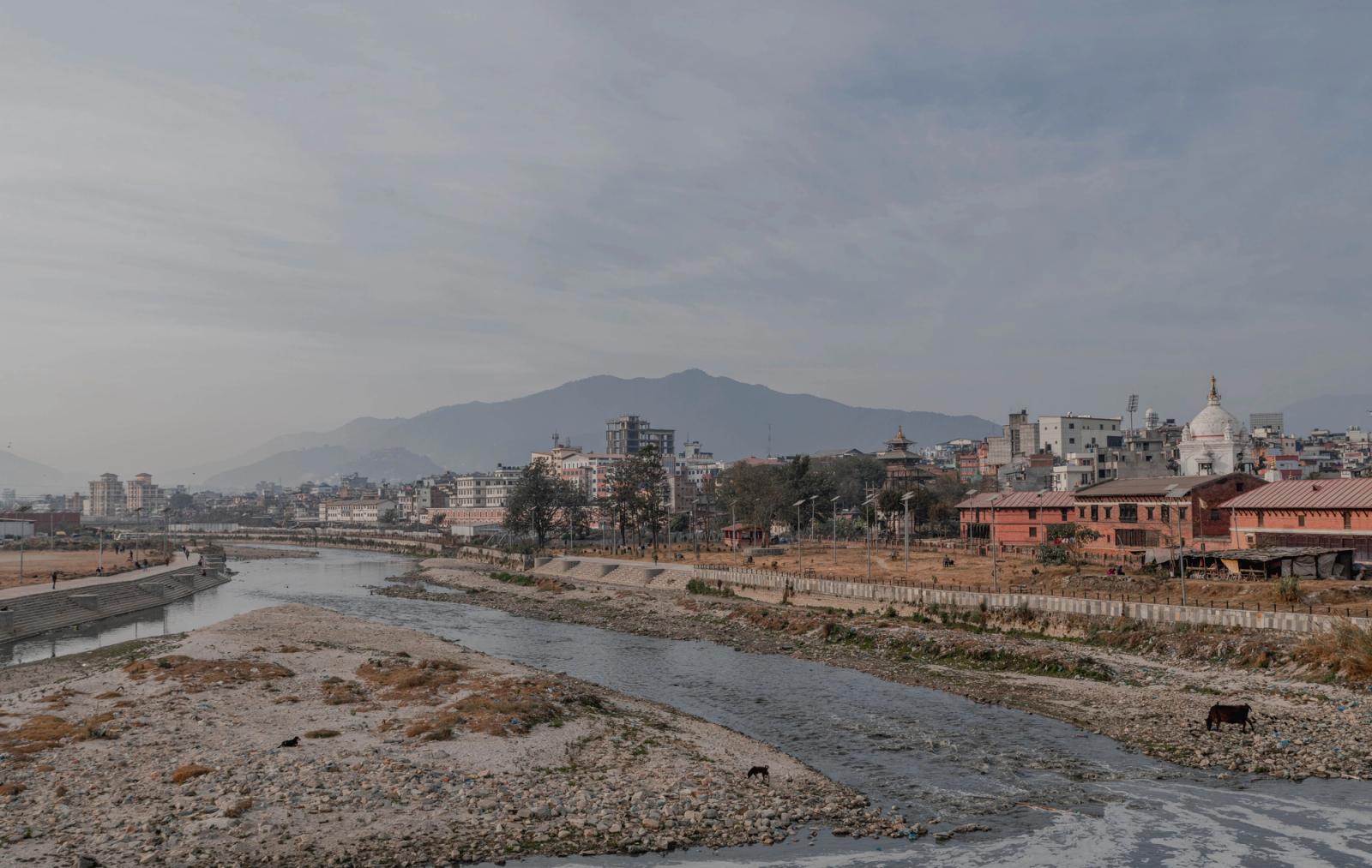 A beautiful view of Kathmandu's river with cityscape and distant mountains captured in a serene setting