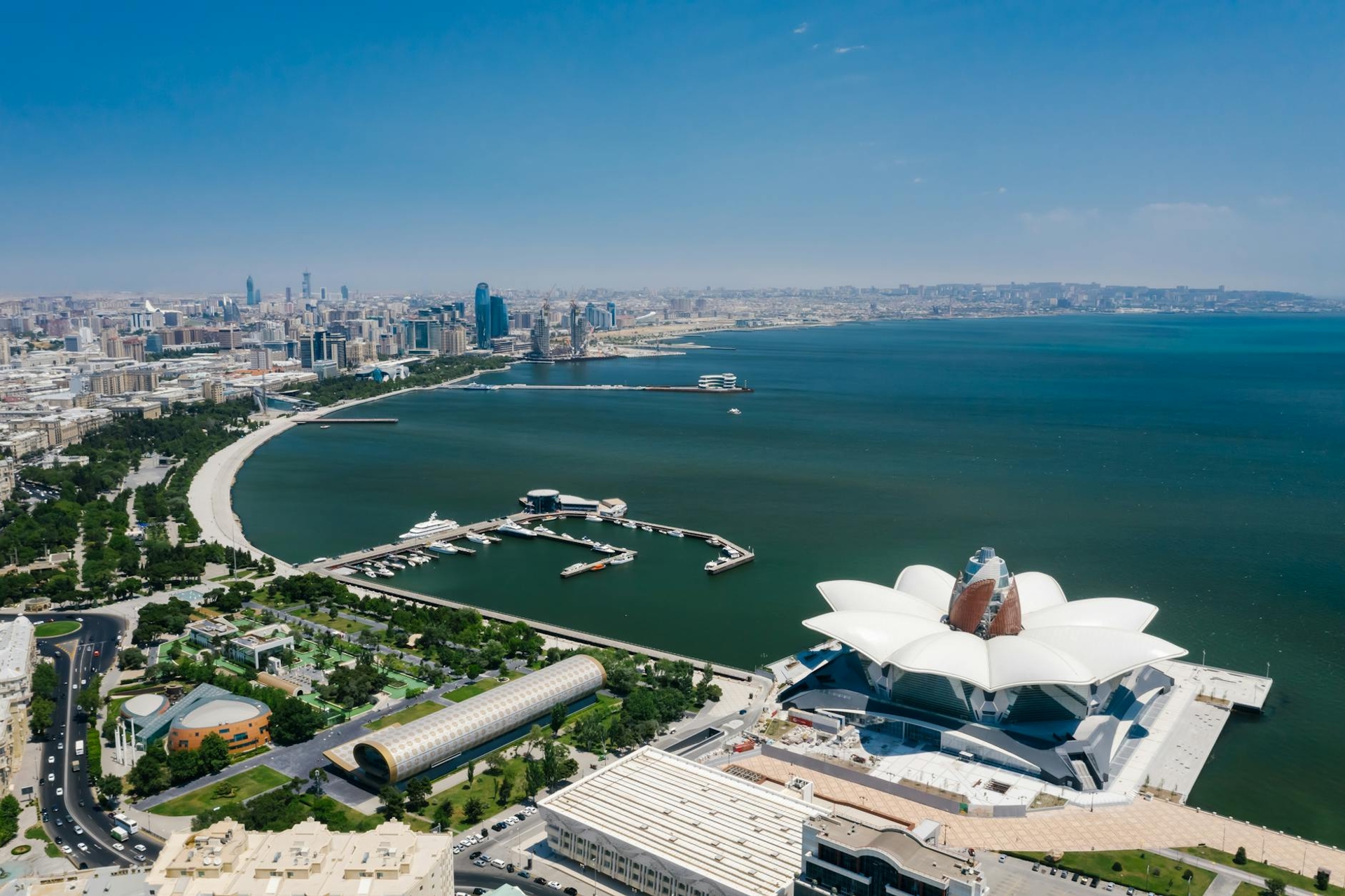 Aerial view of a coastal city with a flower-shaped waterfront building