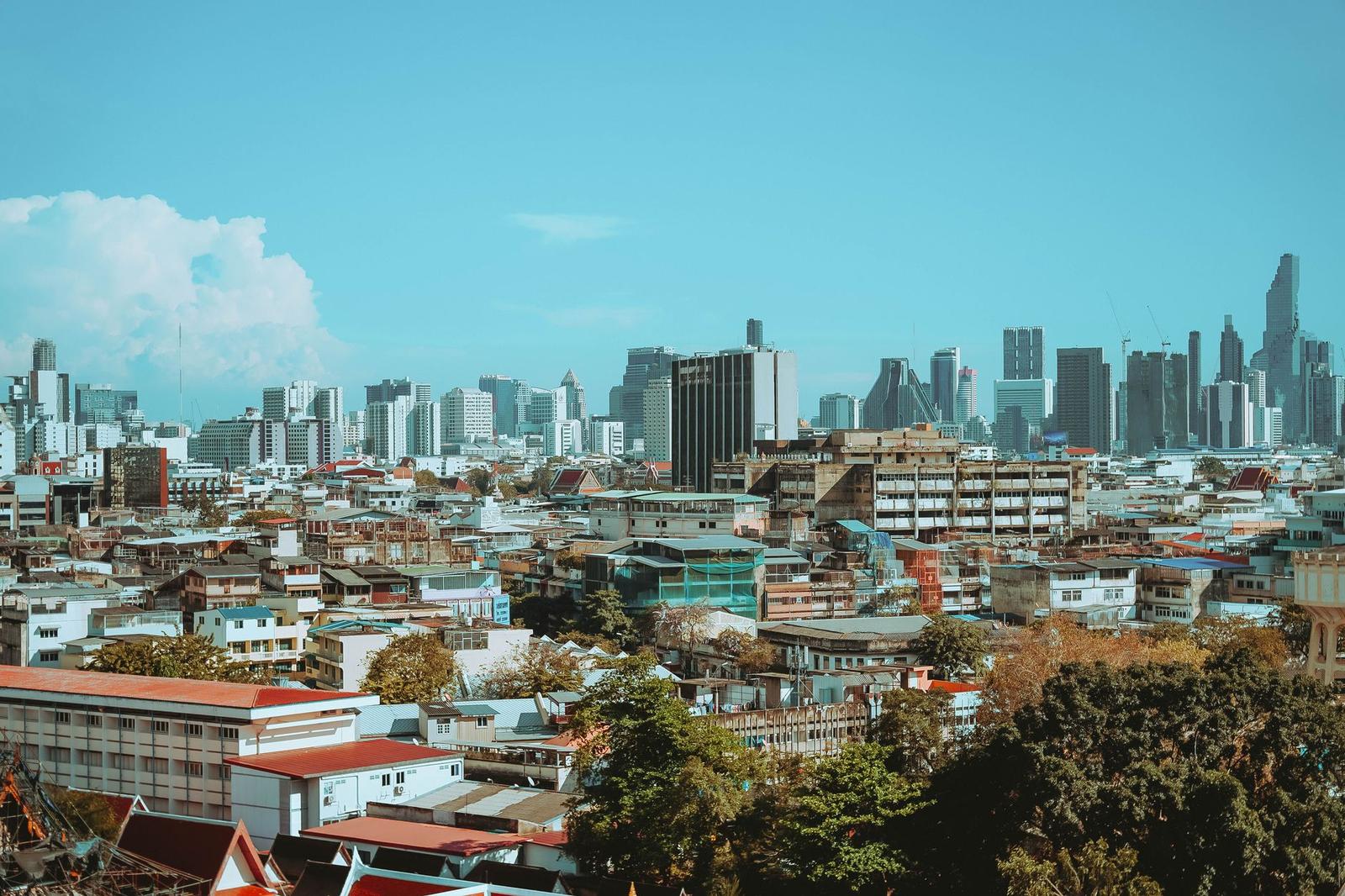 Dense low-rise rooftops stretching toward a modern city skyline