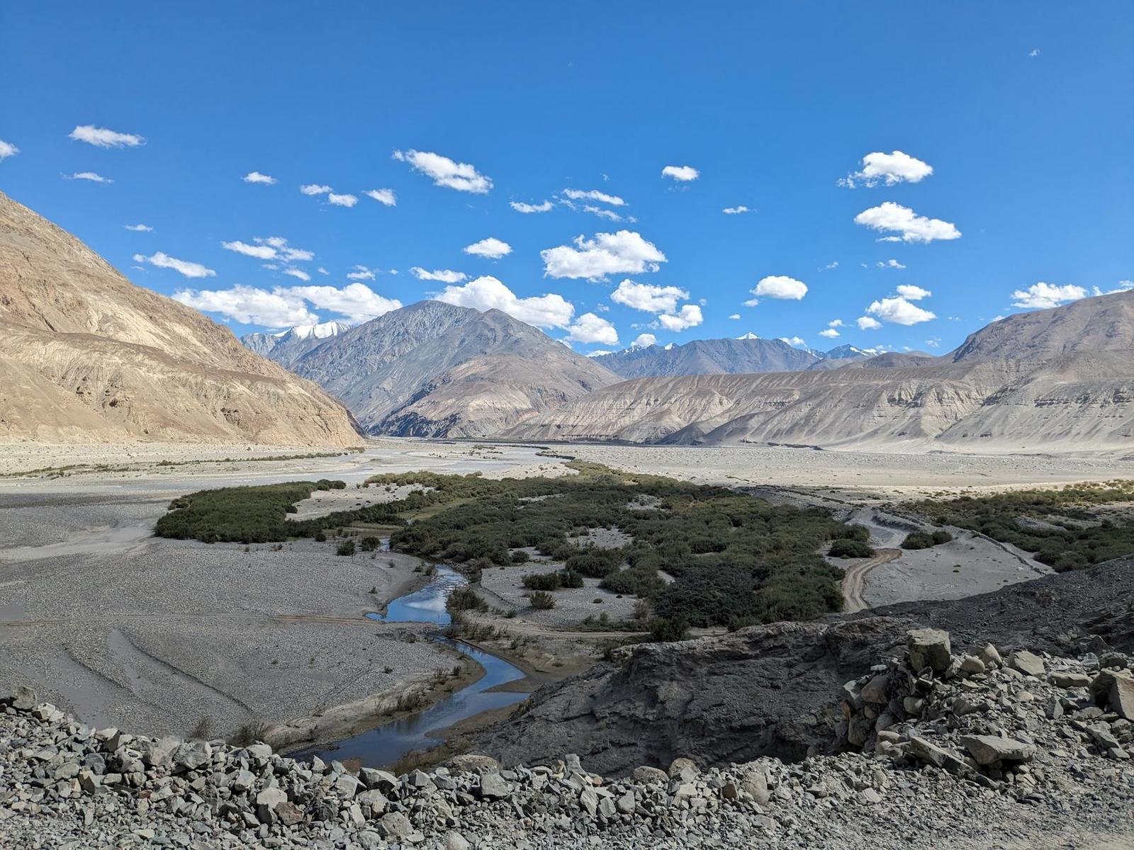 A braided river winding through a wide arid mountain valley