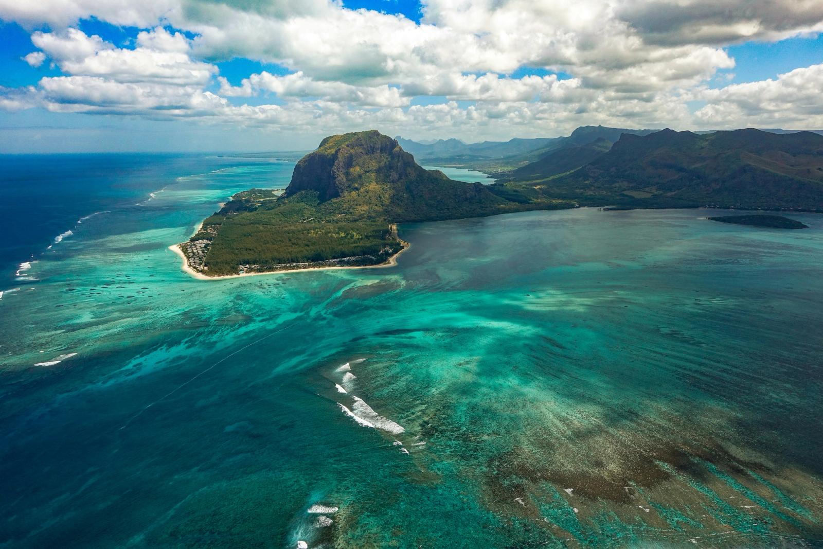 A dramatic mountain headland surrounded by turquoise reef water