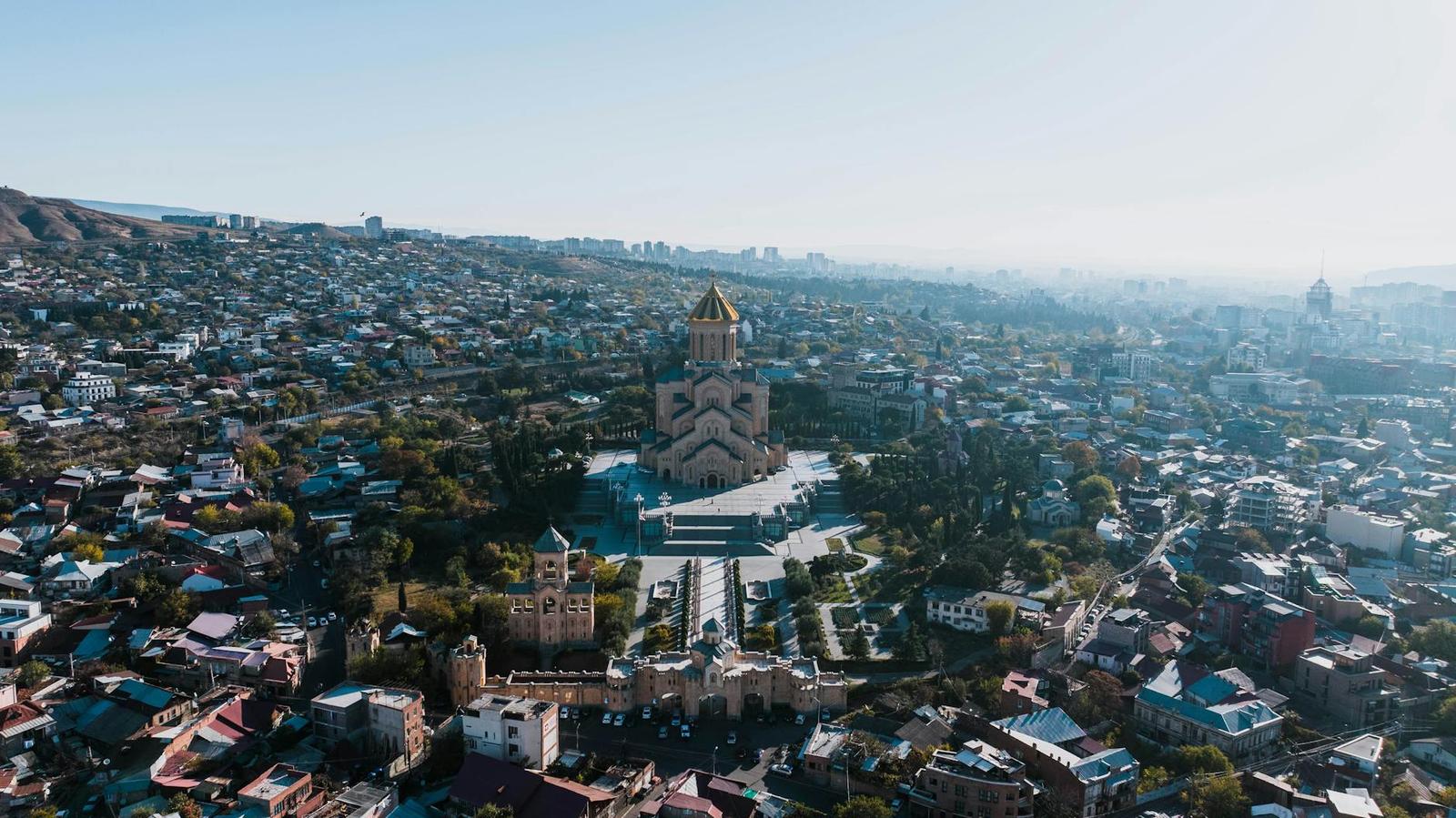 Aerial view of a golden-domed cathedral surrounded by a hillside city