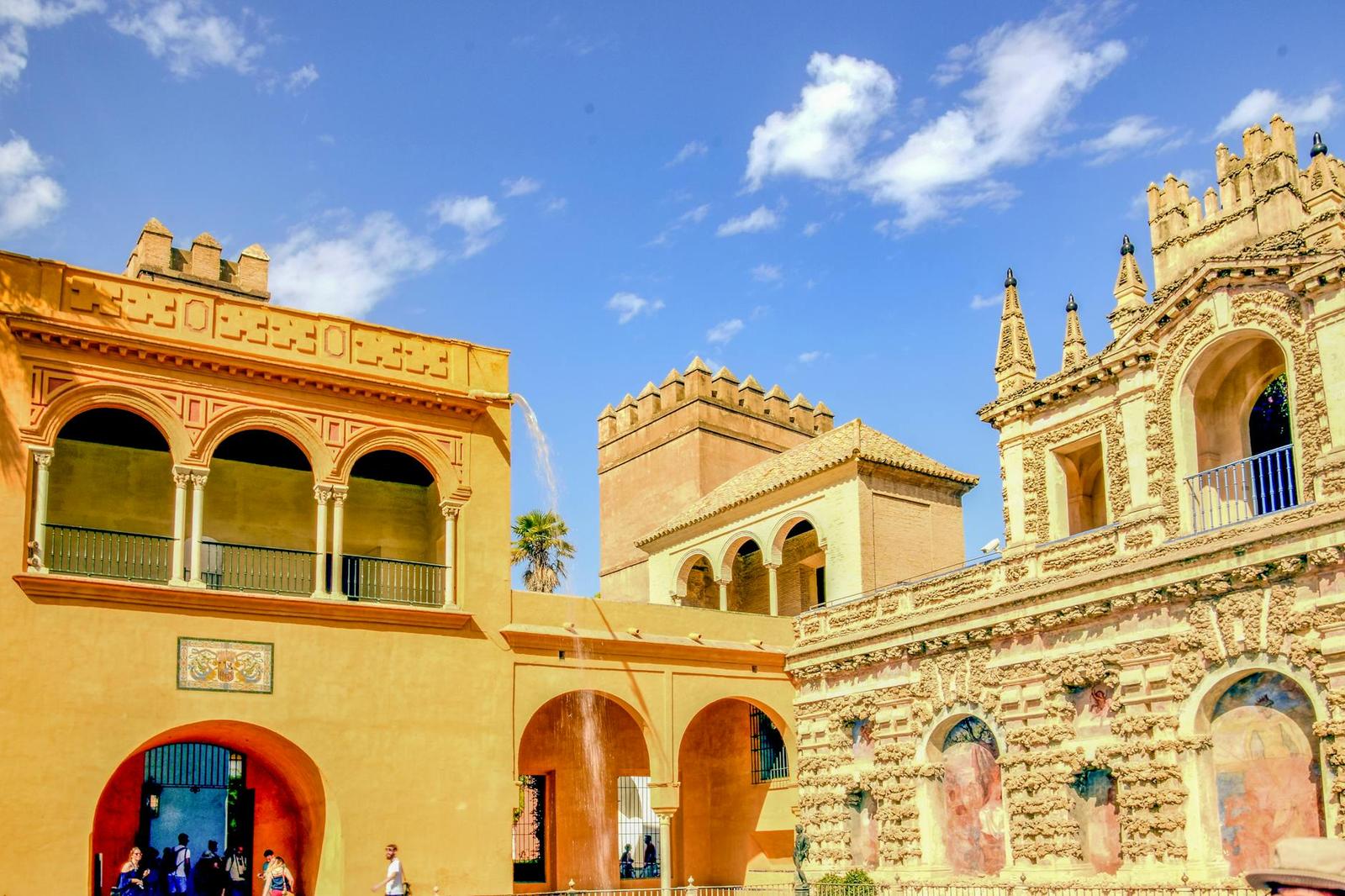 Ornate palace courtyard with Moorish arches and carved stone towers