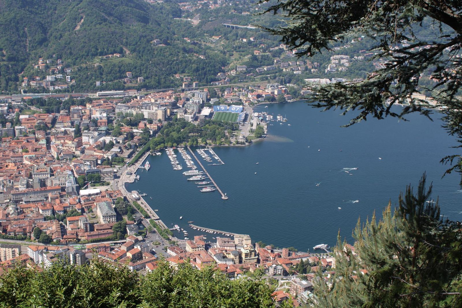 Lakeside town with a marina harbour surrounded by green mountains