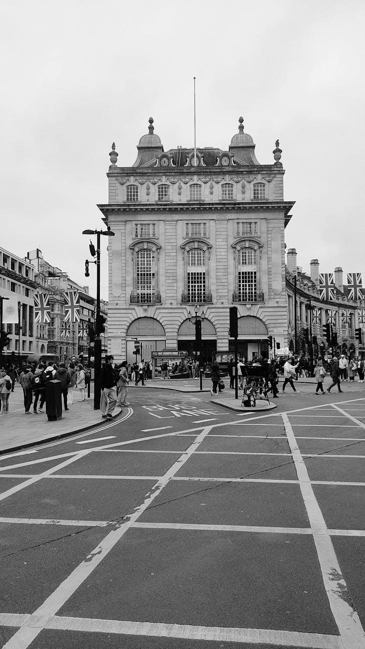 Black-and-white view of pedestrians crossing a busy city plaza