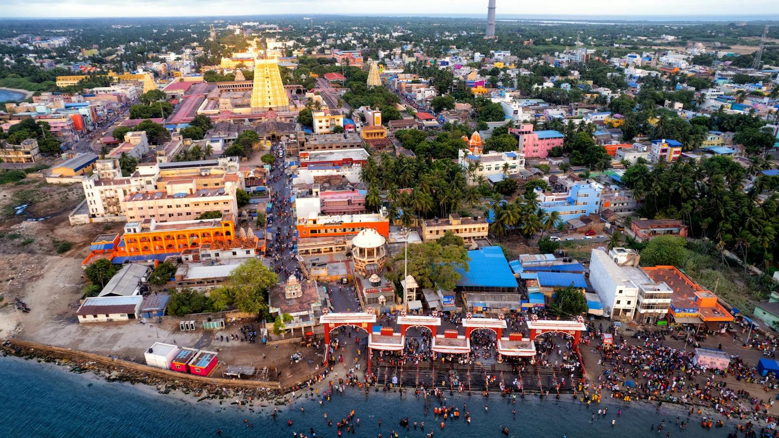 Aerial view of a temple town along the coastline at sunset