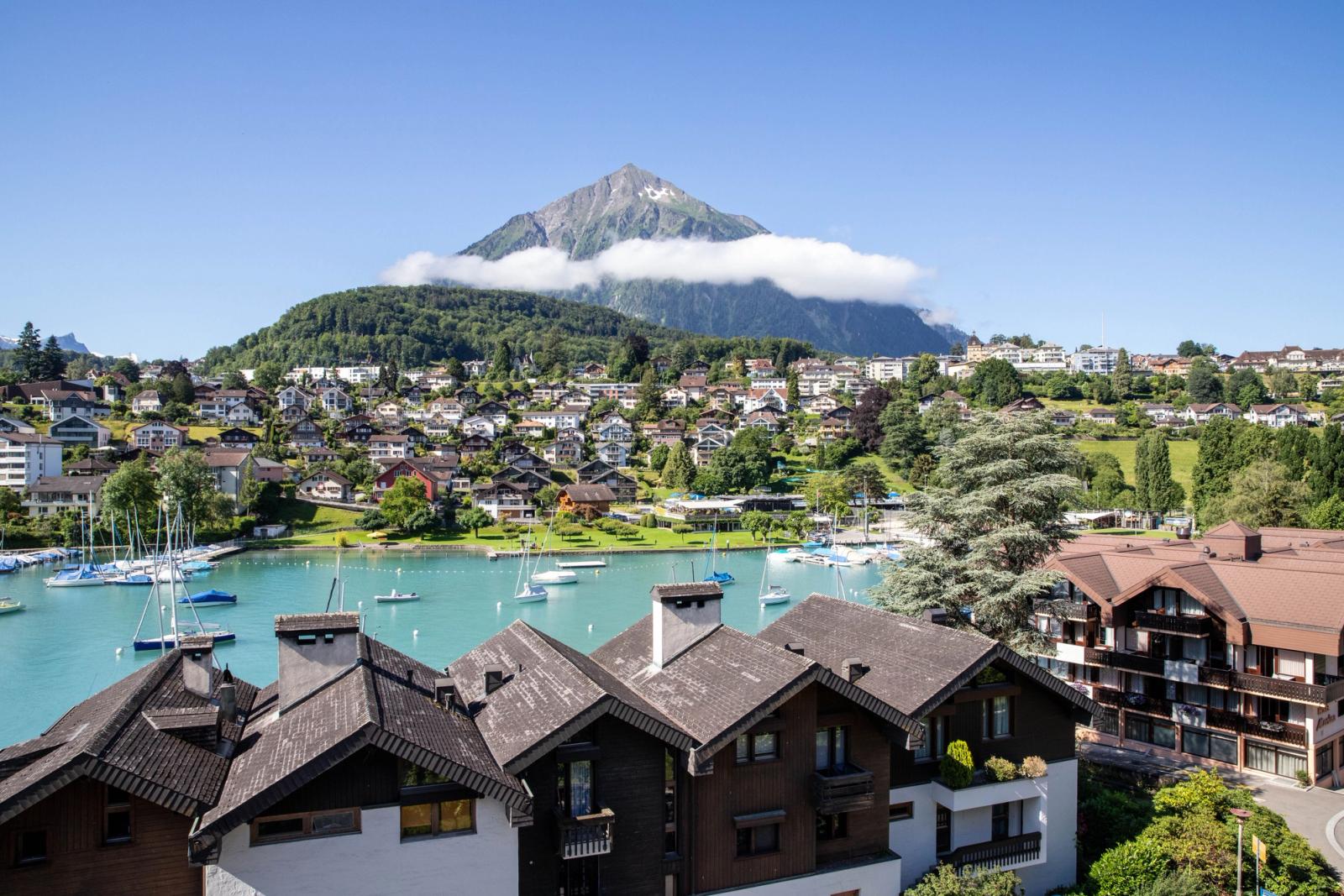Breathtaking aerial view of Brienz, showcasing colorful houses, turquoise lake, and majestic Alps in Switzerland