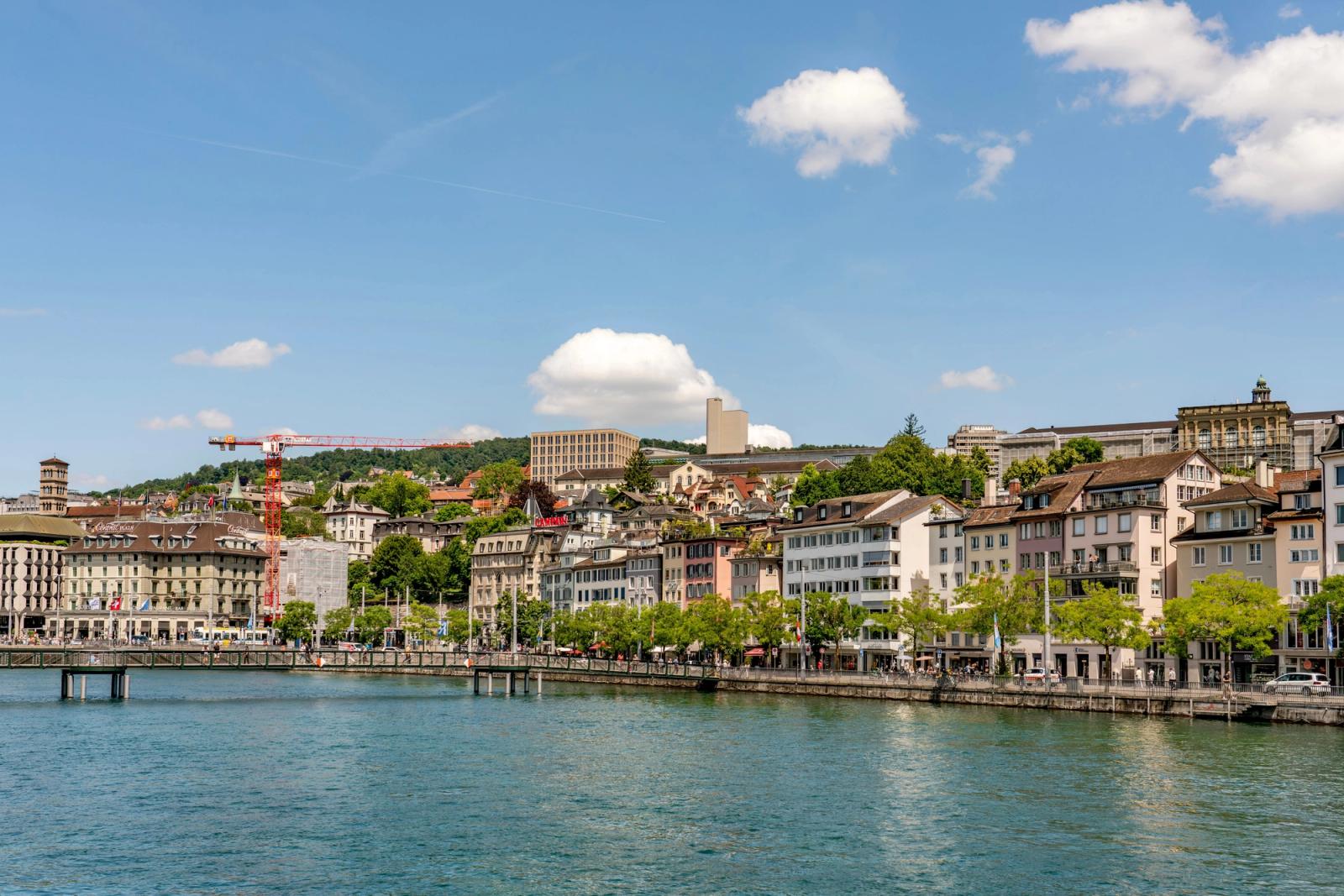 Beautiful waterfront scene in Zurich with historic architecture under a clear blue sky