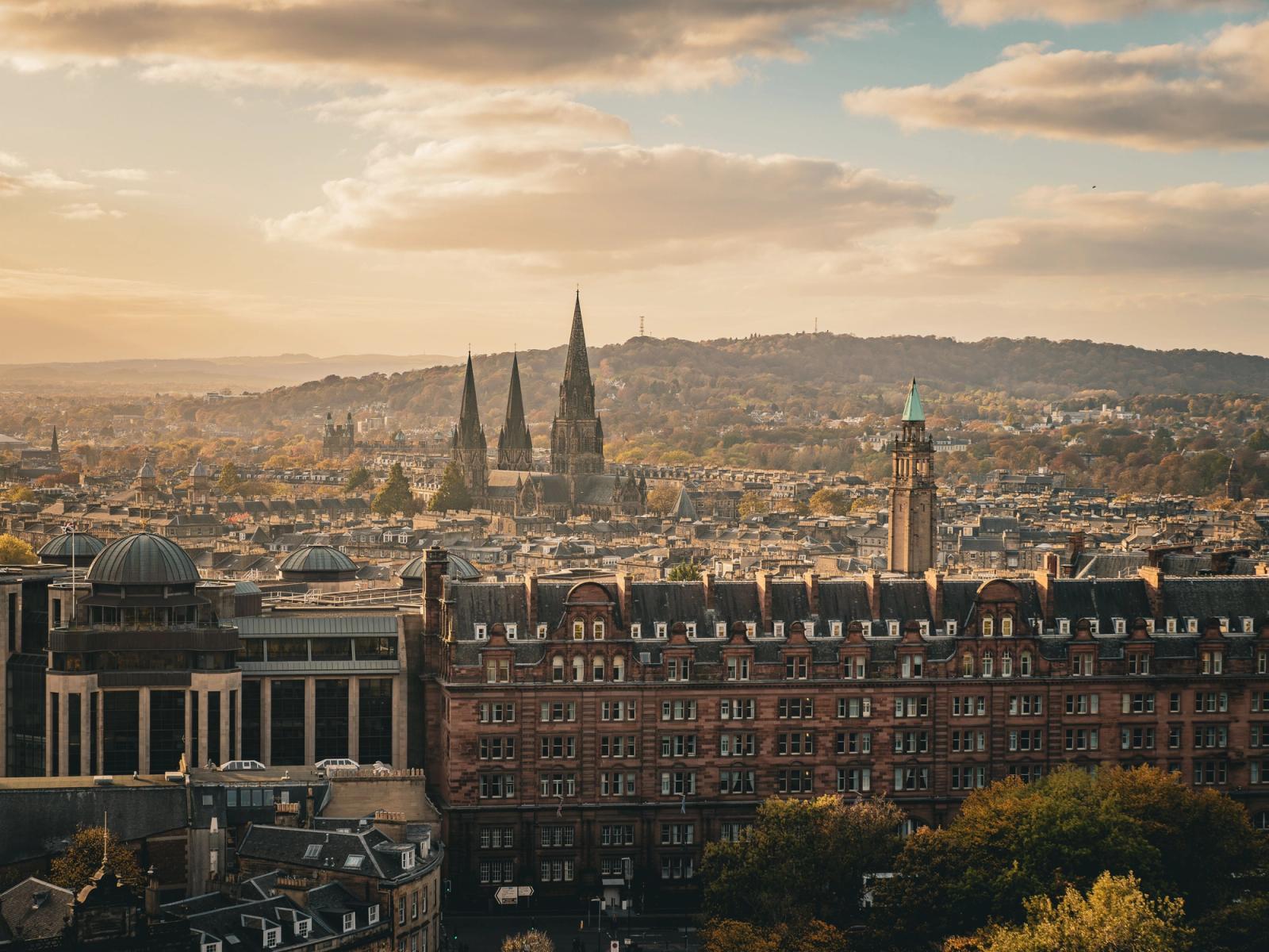 A breathtaking view of Edinburgh's historic skyline at sunset featuring iconic architecture