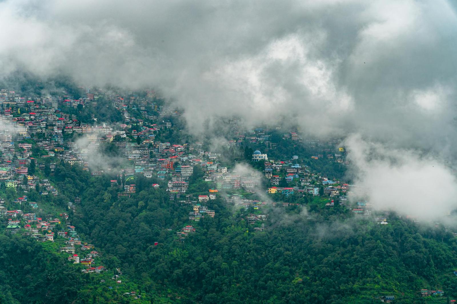 A scenic view of Darjeeling's colorful hillside under clouds