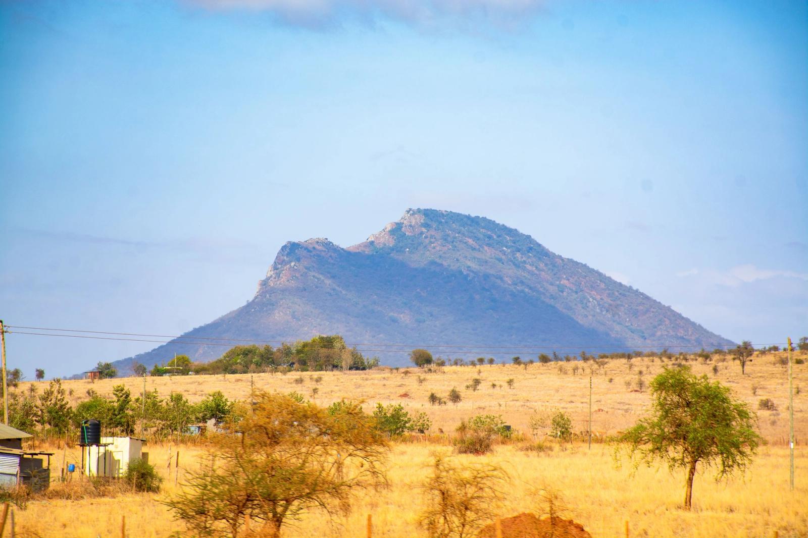 Beautiful view of mountains and savannah landscape in Kajiado, Kenya, under a clear blue sky