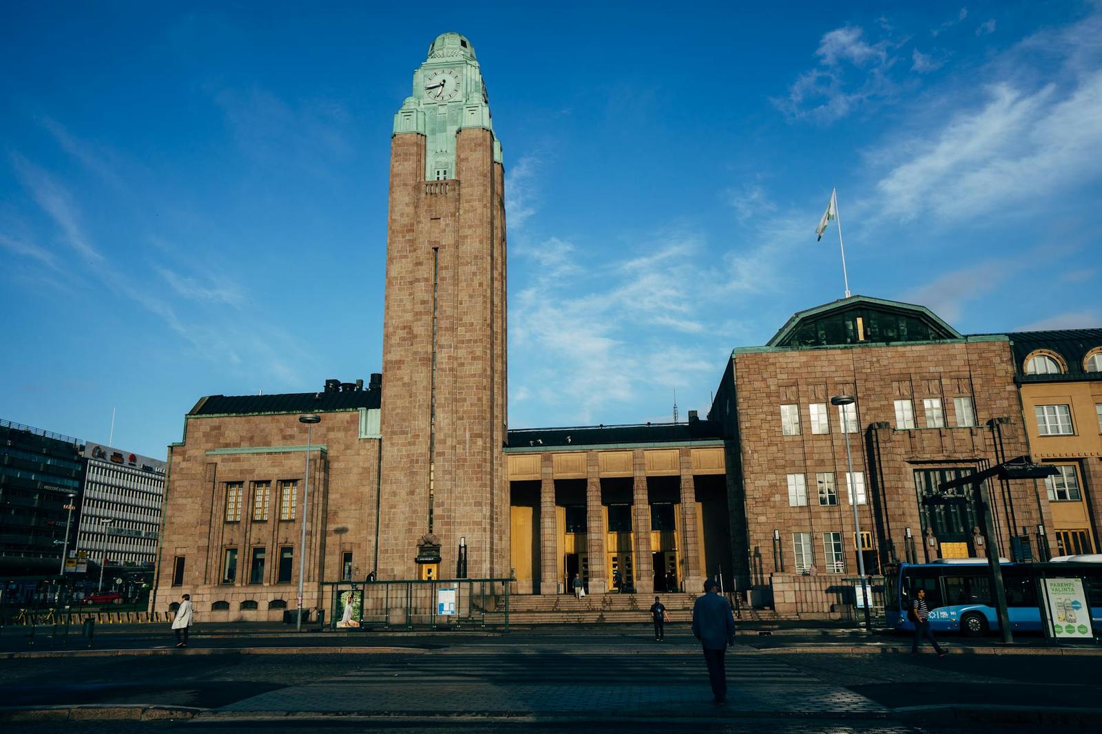 A stone clock tower rising above a grand columned civic building
