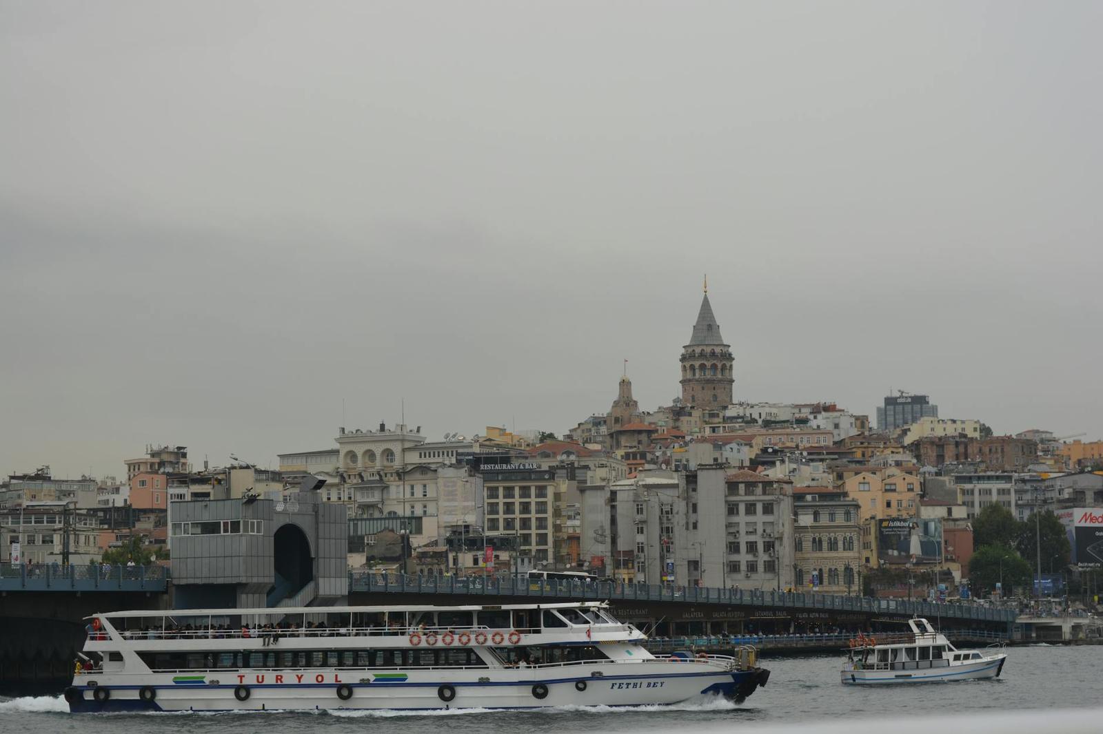 Ferries crossing a strait with a historic clock tower on the shoreline