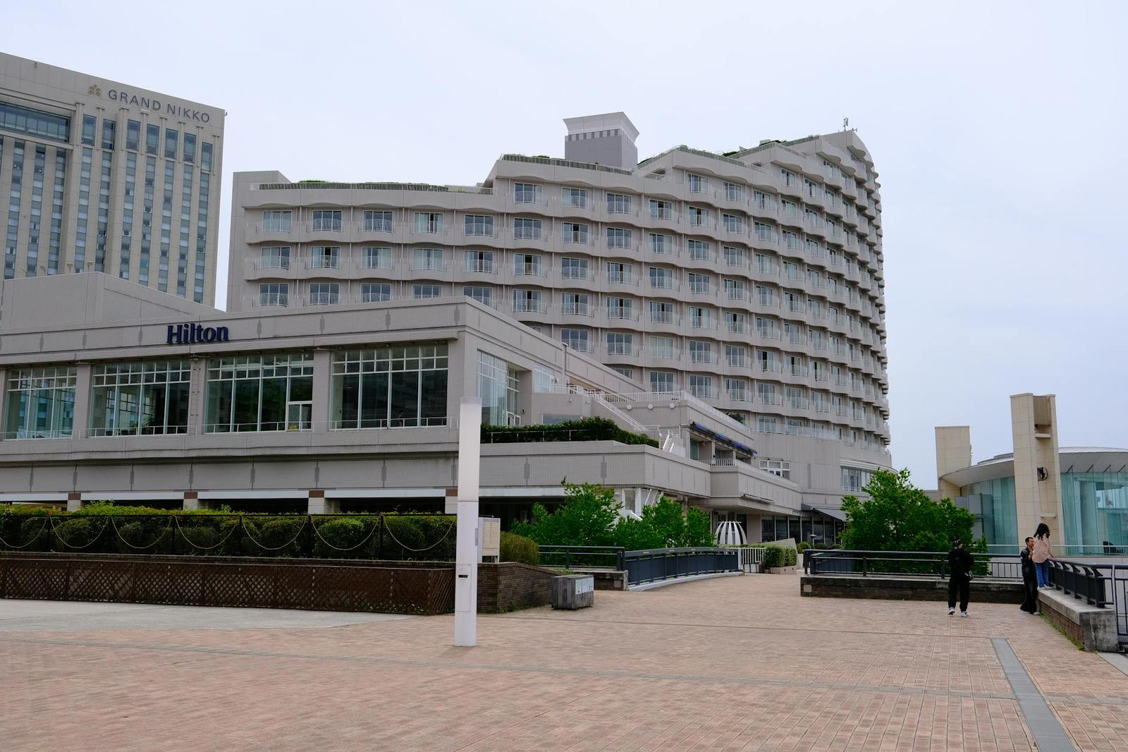 A curved Hilton hotel building with a covered entrance walkway