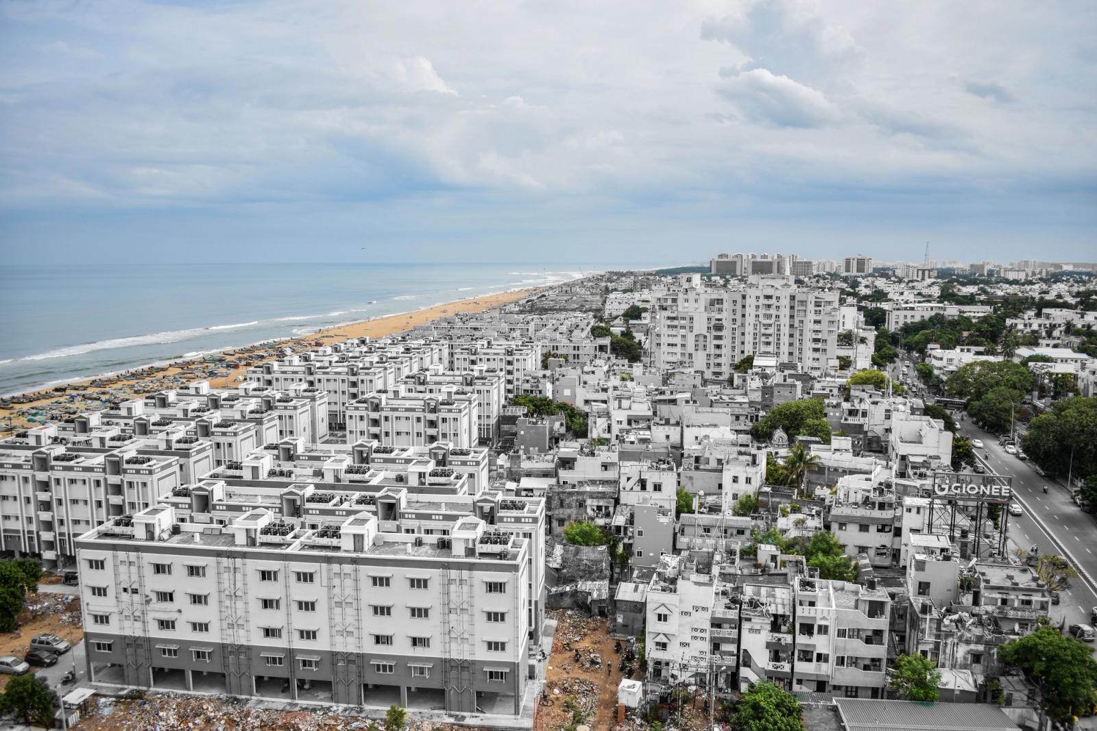 Aerial view of Chennai's urban landscape with Marina Beach in the background