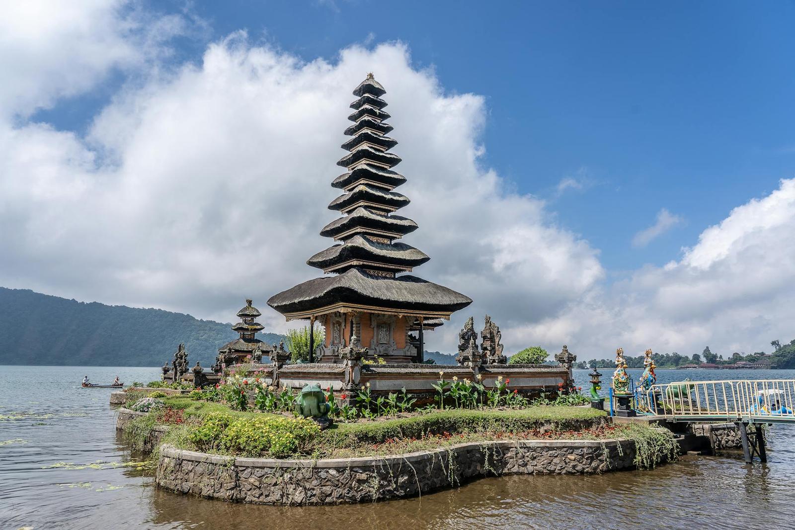 Scenic view of Ulun Danu Beratan Temple against a vibrant blue sky by the lake in Bali, Indonesia