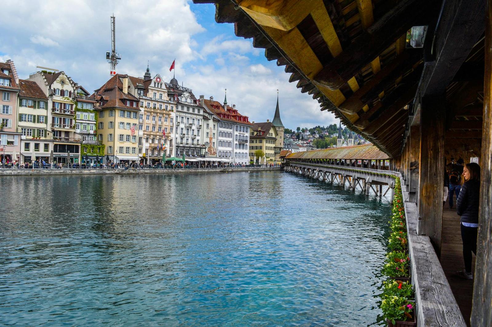 Exterior of aged wooden bridge crossing river channel and leading to historic buildings in old town in daytime