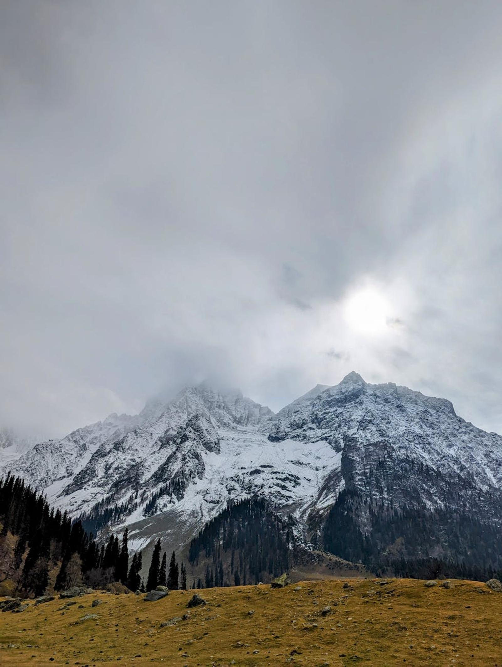 Stunning view of snow-covered mountains in Sonamarg, Kashmir under a cloudy winter sky