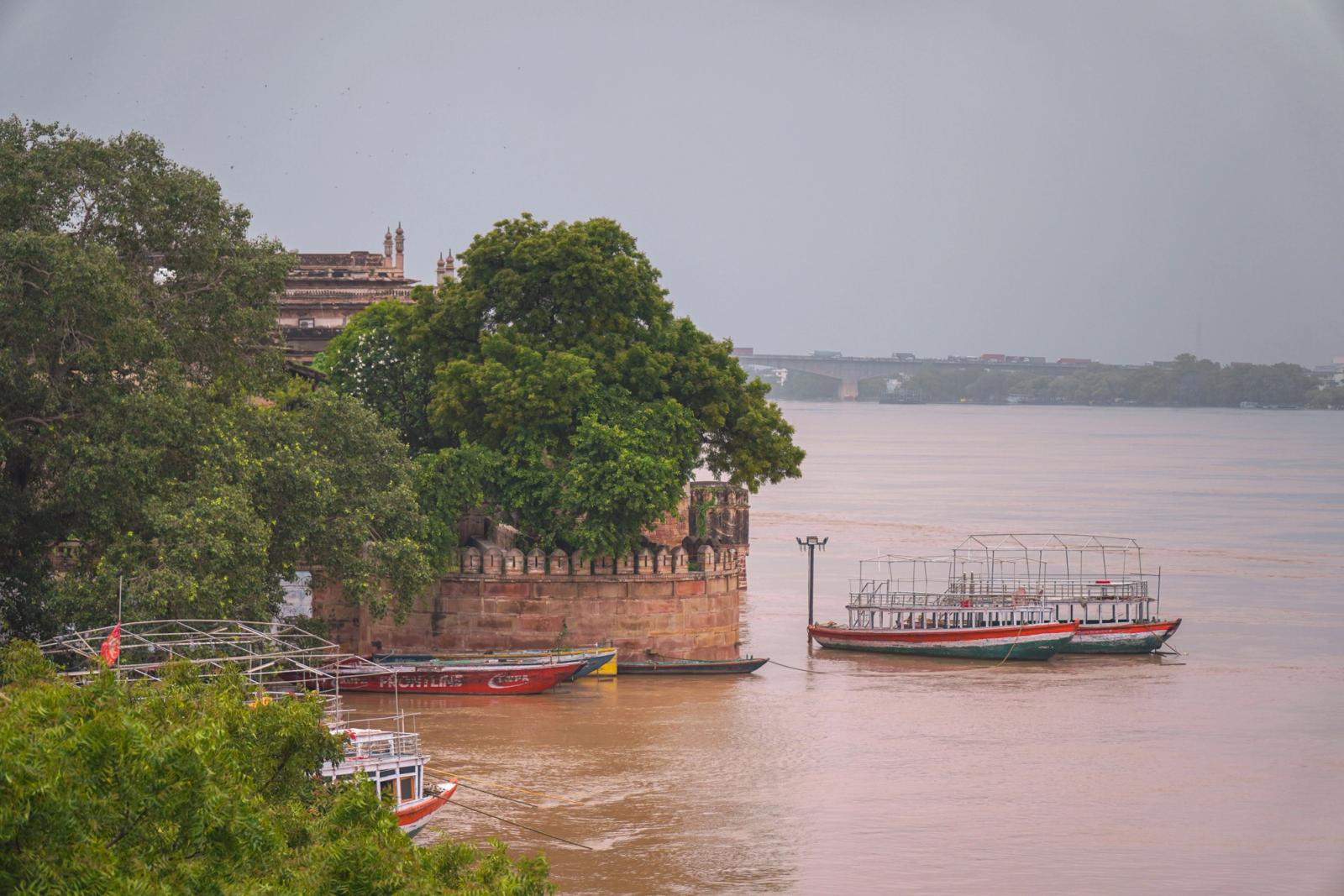 Tranquil river scene in Varanasi with traditional boats and historic architecture