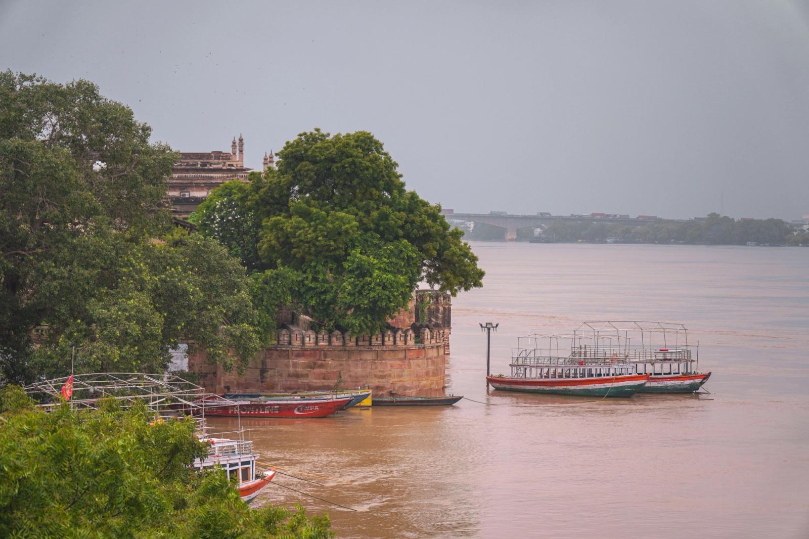 Tranquil river scene in Varanasi with traditional boats and historic architecture
