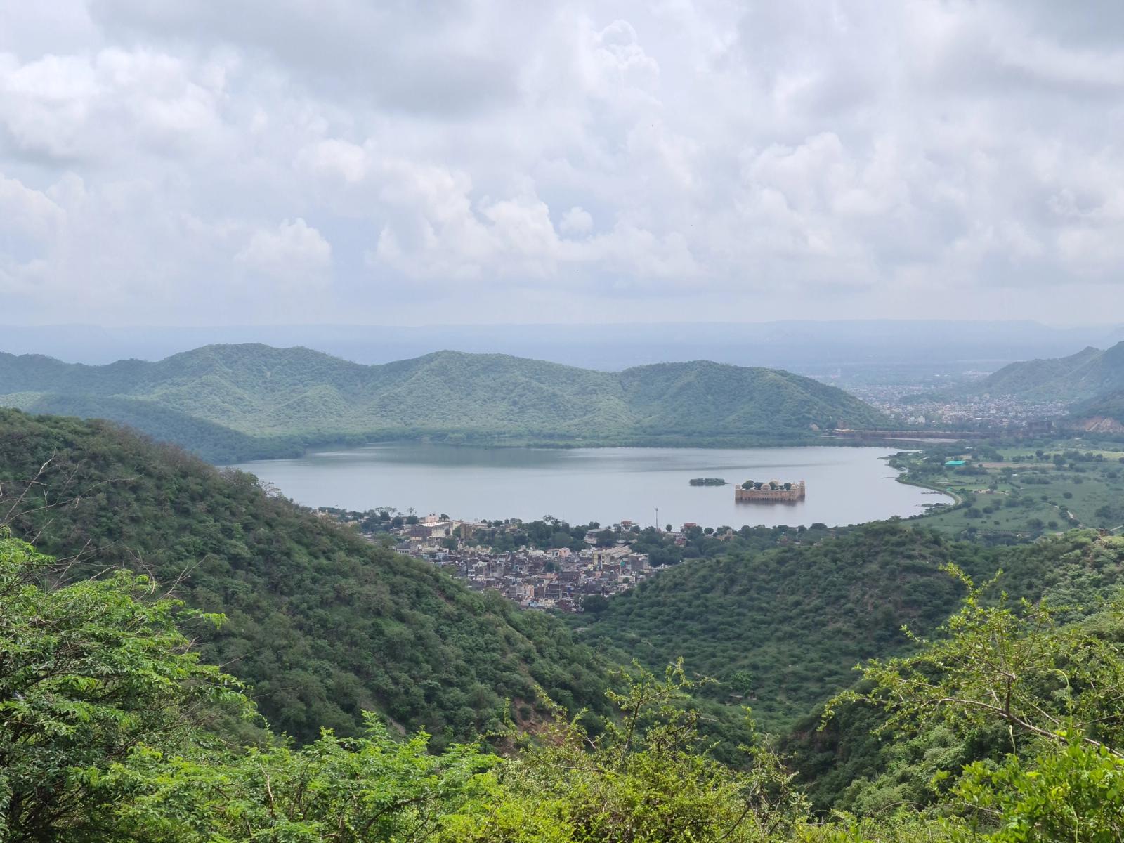 Stunning aerial view of Jal Mahal in Jaipur, India, surrounded by lush greenery and hills