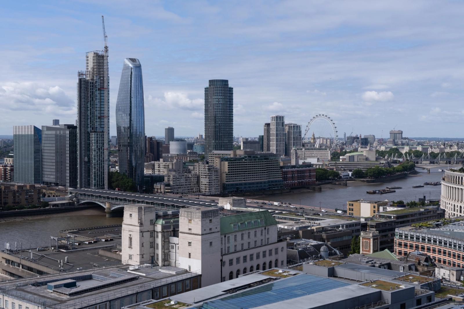 A stunning view of London's skyline with the Thames River and London Eye on a bright day