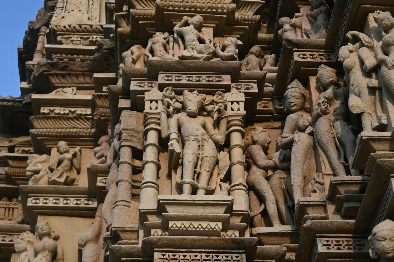 Sandstone temple facade densely carved with figures and ornamental brackets