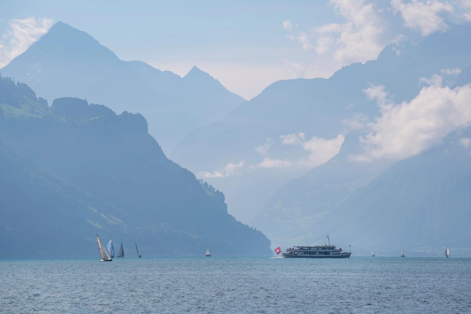 Scenic view of sailboats and a ferry on Lake Lucerne with Swiss Alps backdrop
