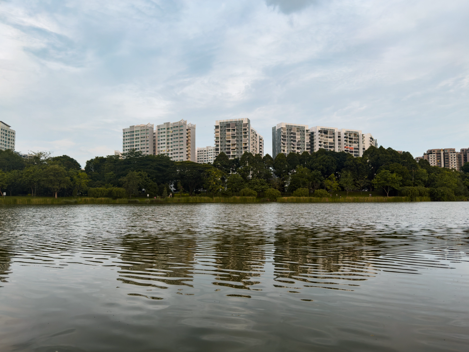 Scenic view of modern buildings reflected in a tranquil lakeside setting