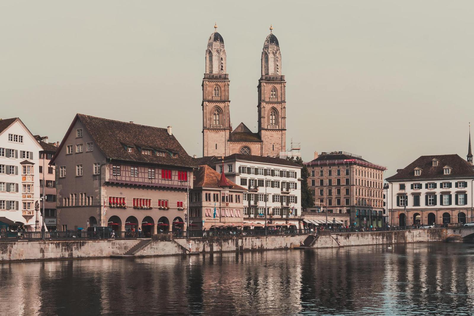 Capture of Zürich's historic Grossmünster Cathedral and riverside architecture reflecting on the water