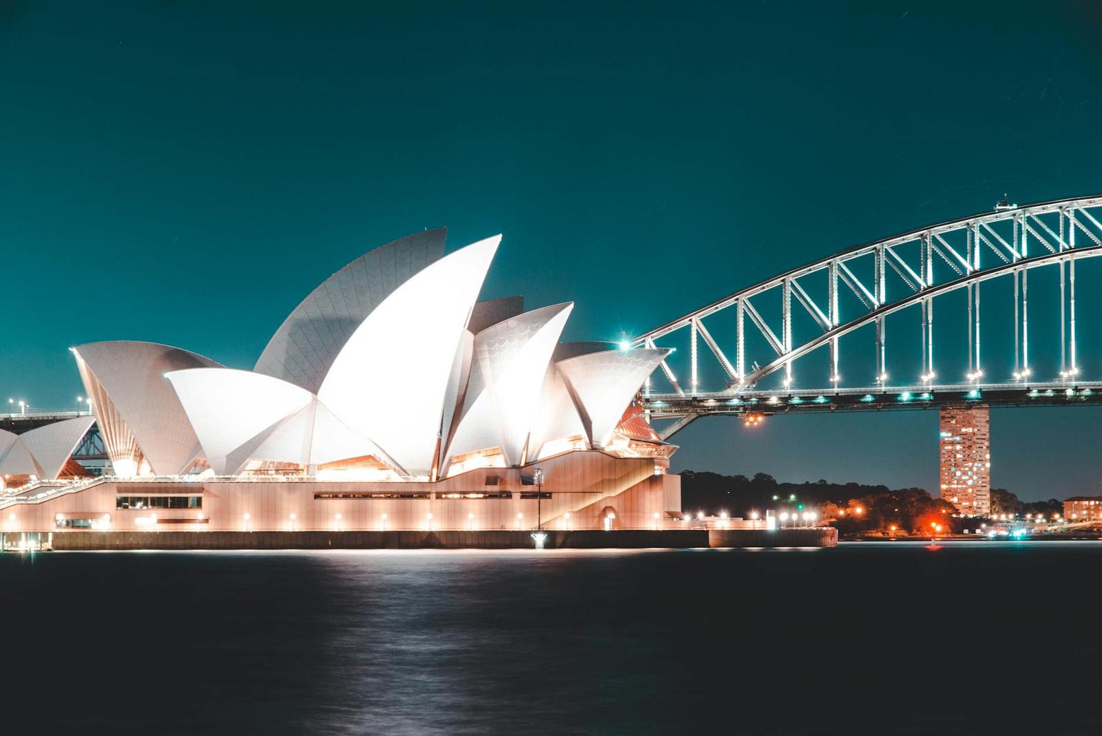 Stunning night view of Sydney Opera House and Harbour Bridge, beautifully illuminated against a clear sky