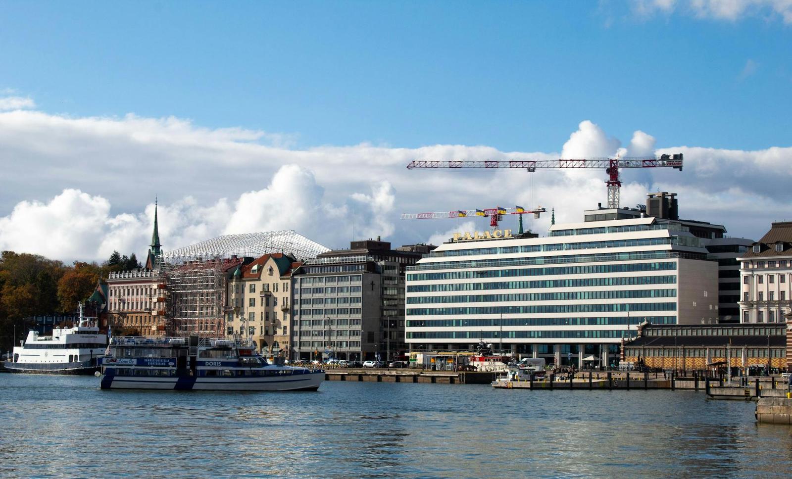 A waterfront city skyline with boats moored beside modern buildings