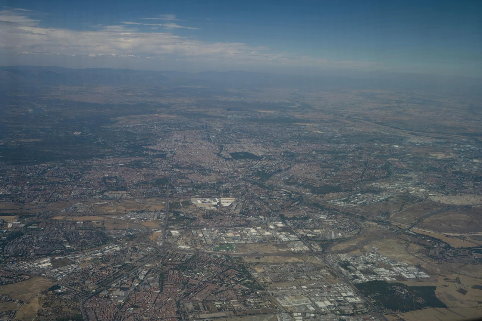 Aerial photograph showcasing the urban expanse of Madrid under clear skies, highlighting the city's structure