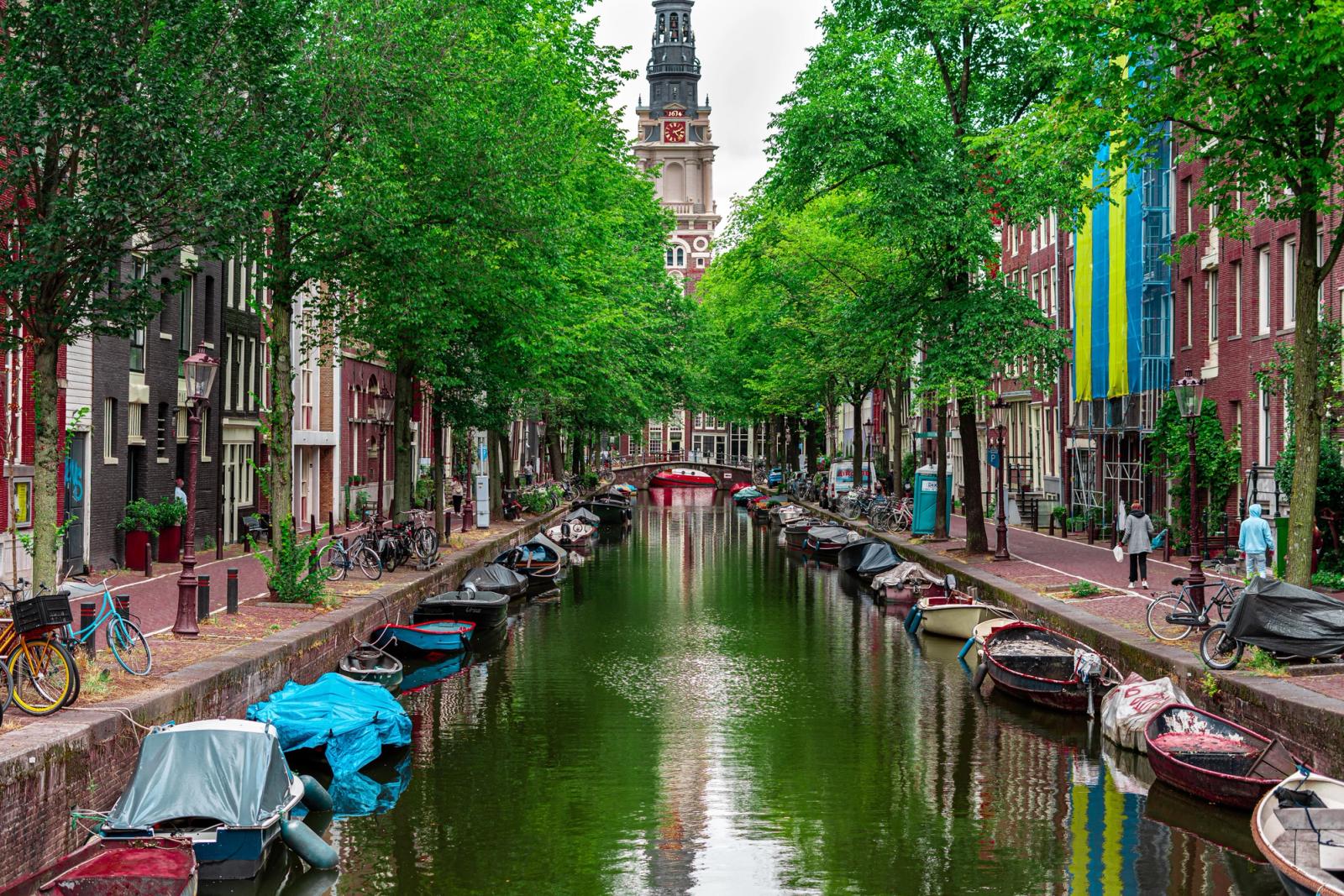 Peaceful Amsterdam canal with boats and view of Zuiderkerk tower