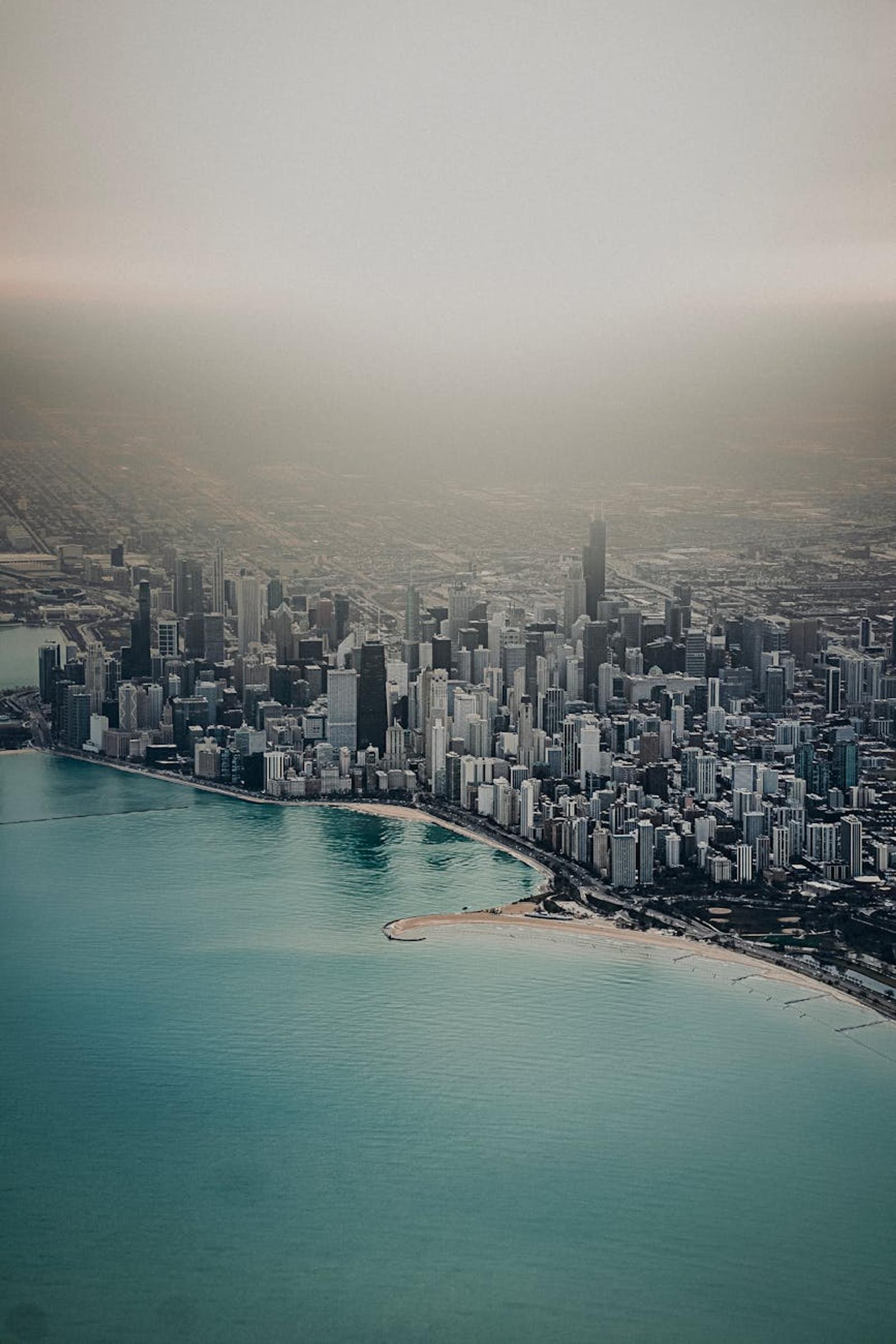 Aerial view of a lakefront skyline wrapped in haze