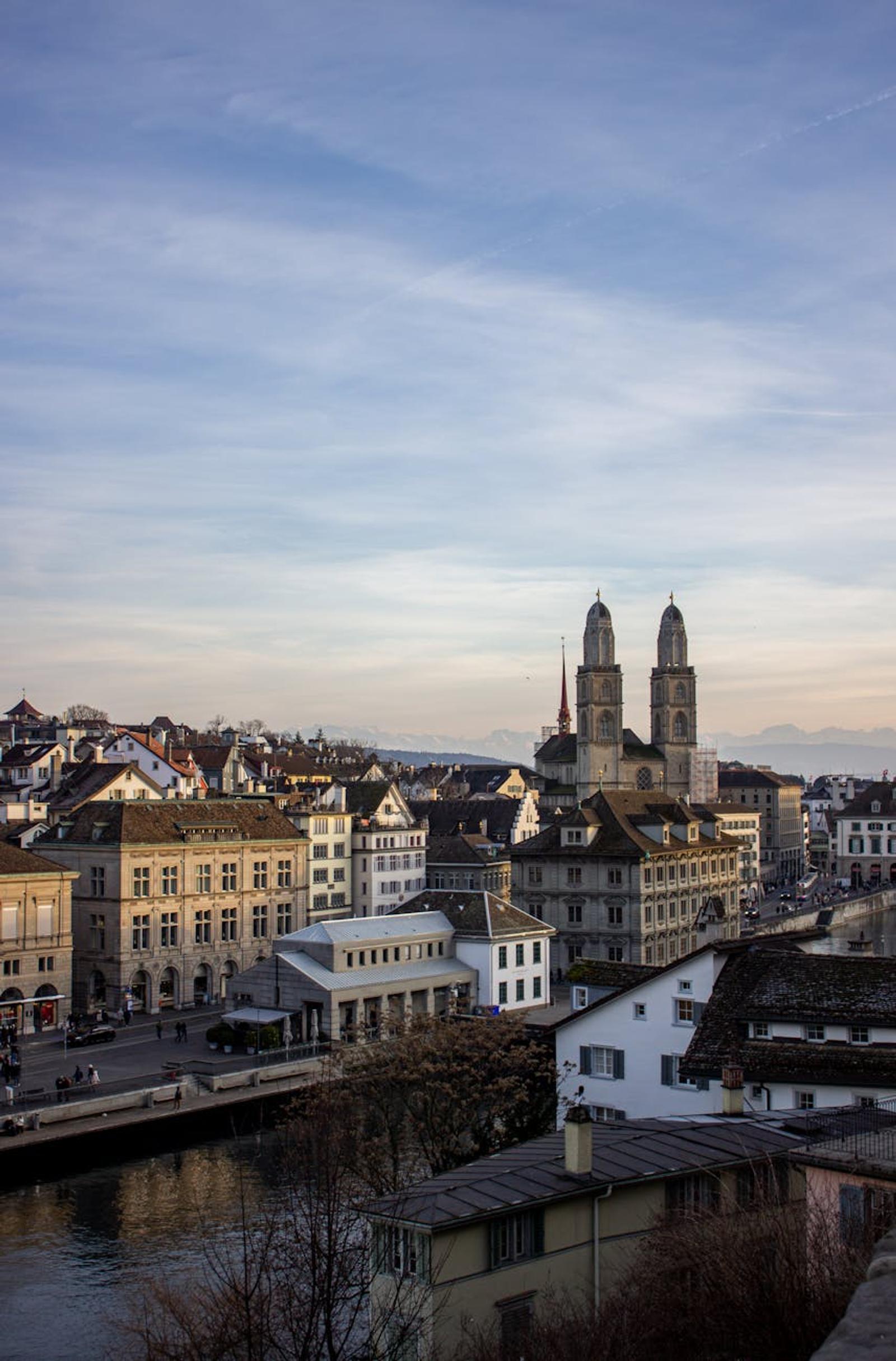 Twin church spires rising above a riverside old town skyline