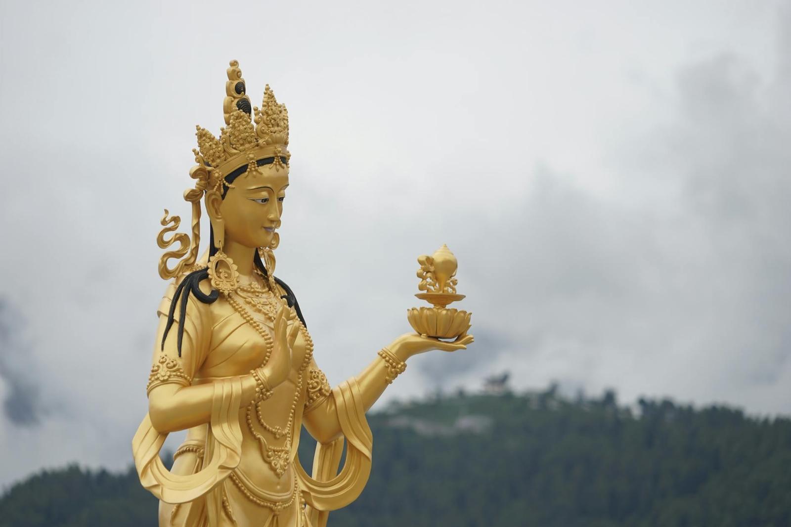 Majestic golden Buddhist statue in Thimphu showcasing spiritual artistry amidst nature