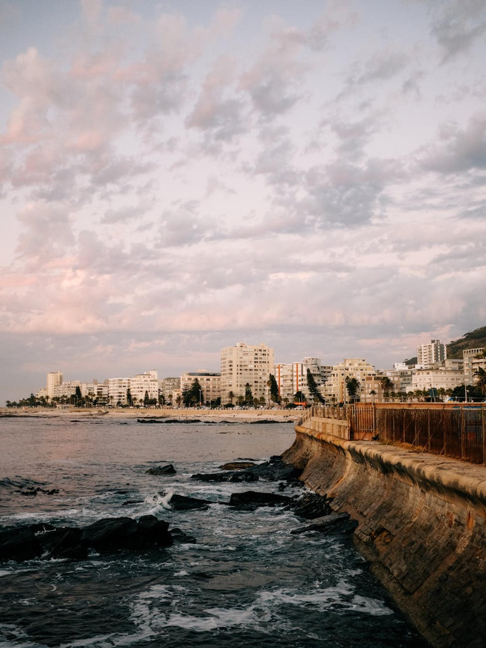 Seaside promenade with beachfront buildings under a pastel evening sky