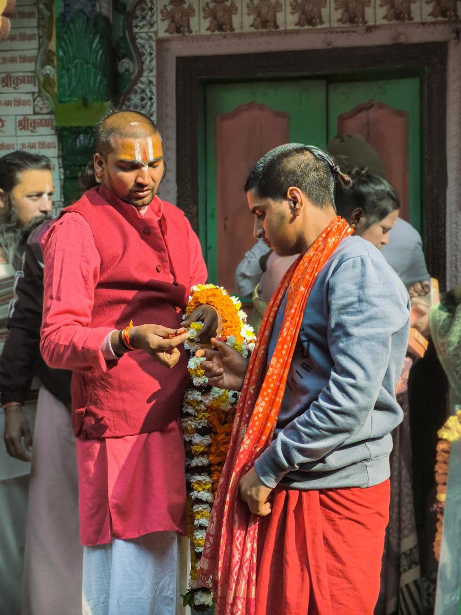 Priests exchanging a floral garland during a temple ceremony