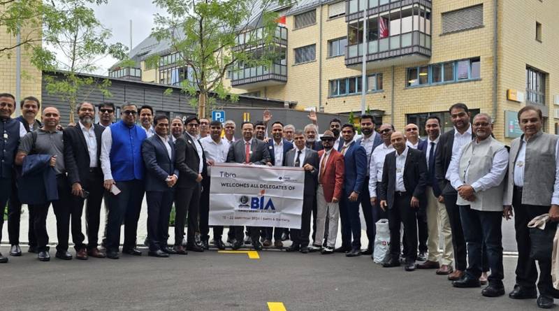 A group of delegates posing outdoors in front of a modern building