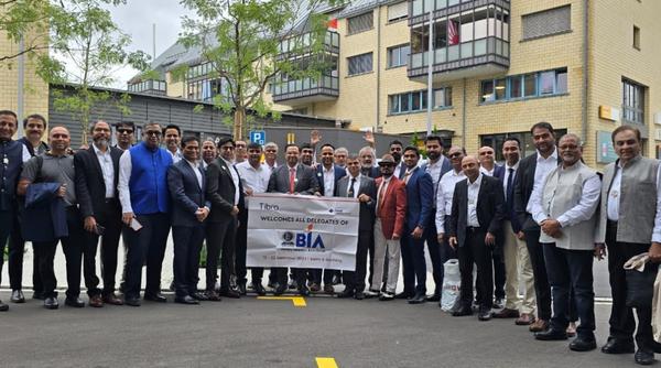 A group of delegates posing outdoors in front of a modern building